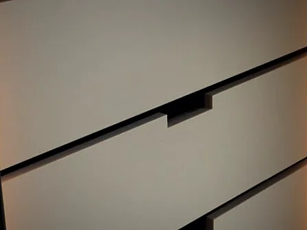 Detalhe da marcenaria Metri — gaveta, rasgo e iluminação embutida